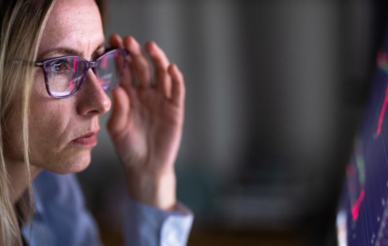 nő kékfényszűrős szemüvegben nézi a monitort